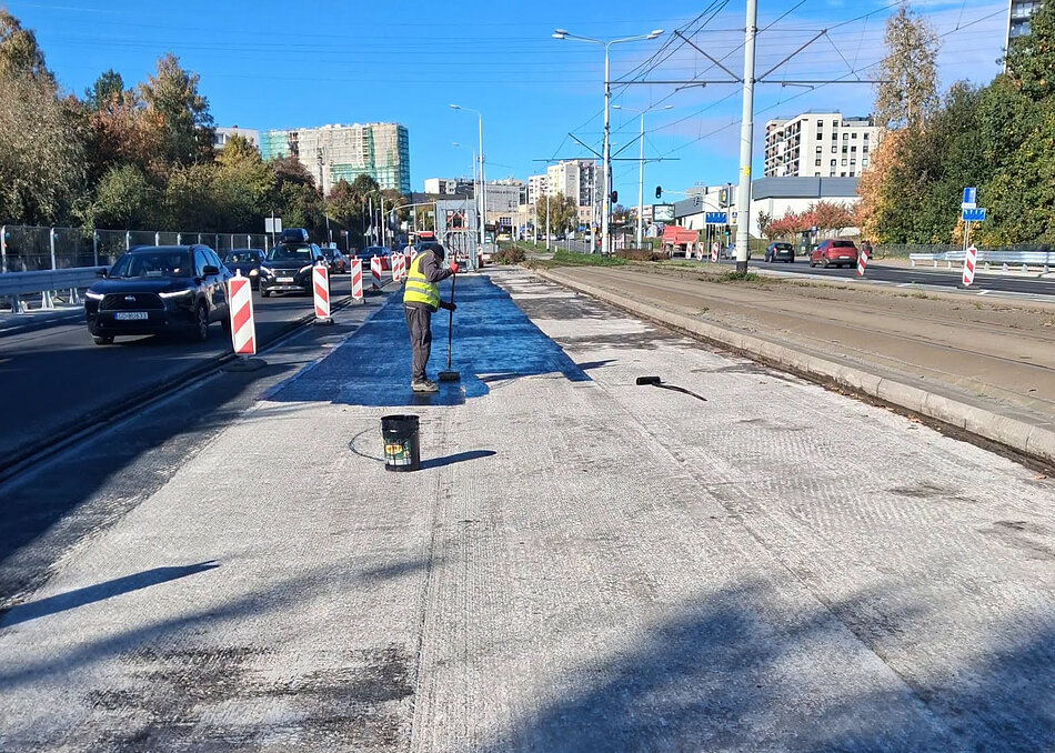 na zdjęciu robotnik rozkłada czarną papę na wiadukcie