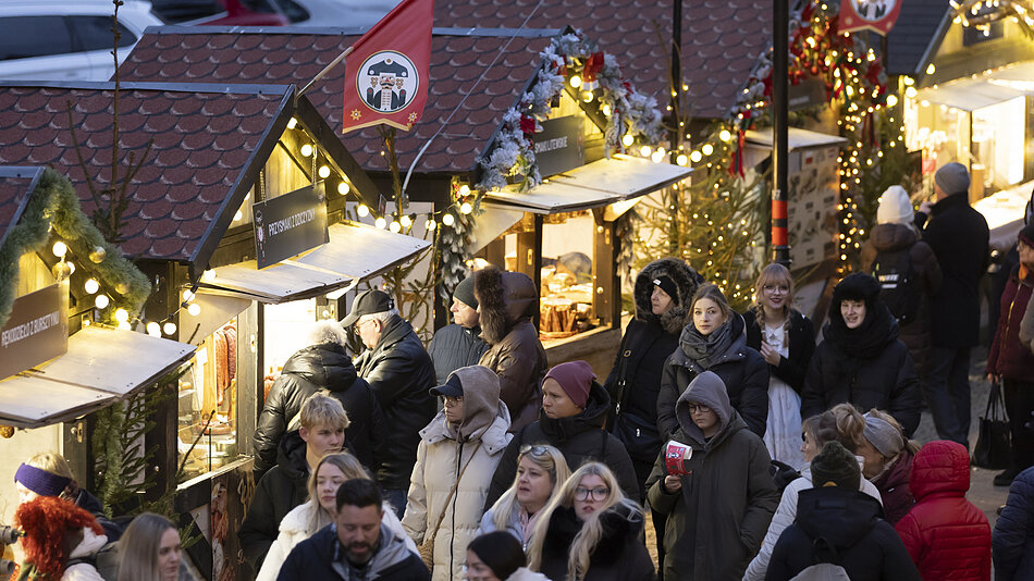 plac z iluminacją świąteczną na środku, wokół zabytkowe budynki i ludzie