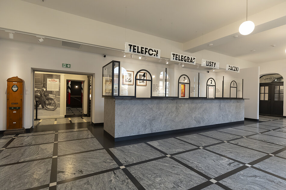 przestrzeń muzeum imitująca przedwojenną pocztę z okienkami