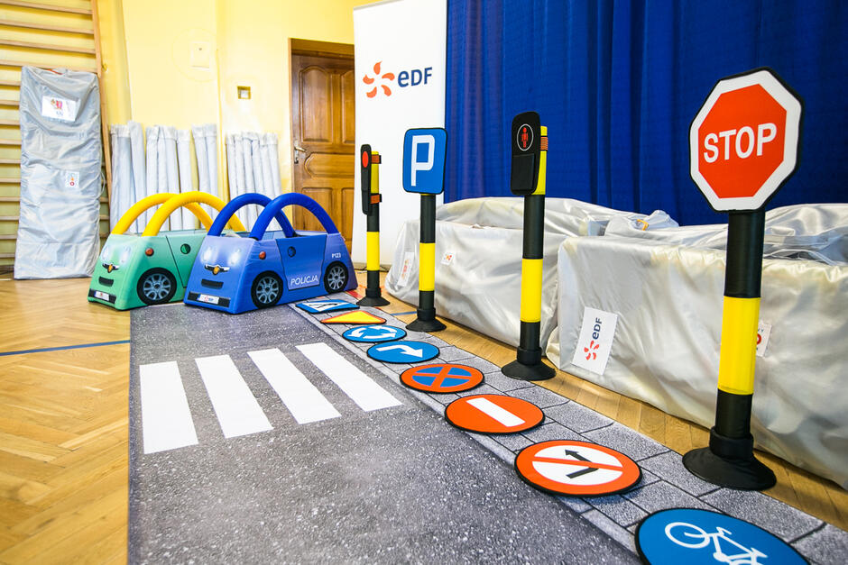 Na zdjęciu widoczny jest zestaw mini znaków i pojazdów przeznaczonych do nauki zasad ruchu drogowego