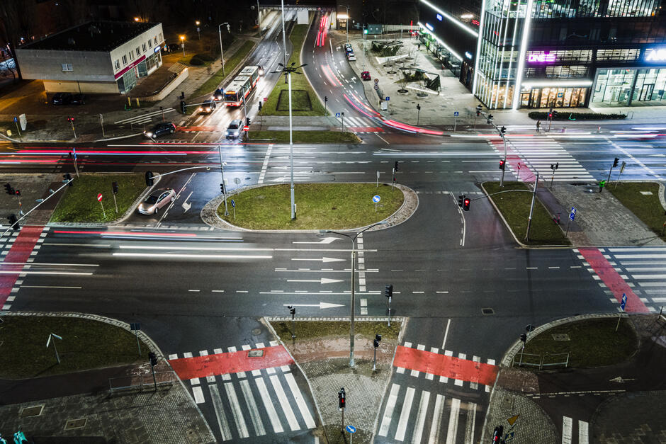 Na zdjęciu widoczne jest skrzyżowanie al. Grunwaldzkiej z ulicami Kołobrzeską oraz Bażyńskiej w nocnej perspektywie ujęcia z lotu ptaka