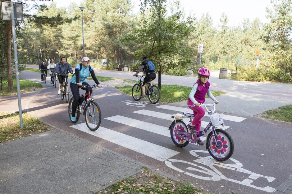 Na zdjęciu widoczni są rowerzyści przejeżdżający drogą rowerową w Pasie Nadmorskim na ul. Jantarowej