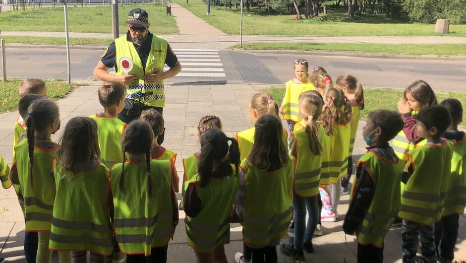 strażni z grupą dzieci stoi przed przejściem dla pieszych
