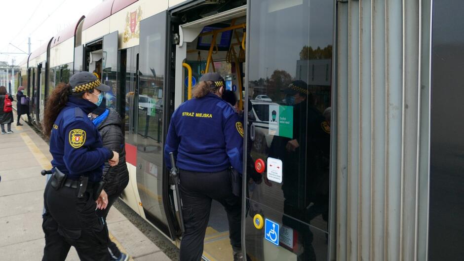 strażnicy wchodzą do tramwaju.JPG