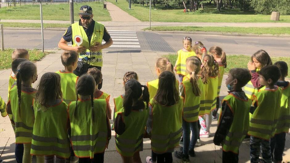 Strażnik tłumaczy uczniom zasady beezpiecznego zachowania na drodze