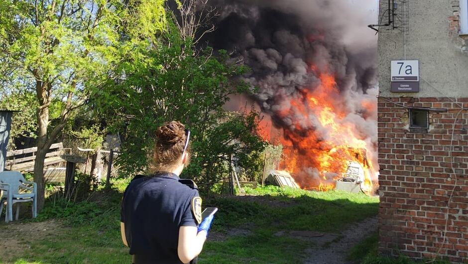 strażniczka obserwuje pożar przy ulicy Dworkowej 7a. Pali się drewniana szopa w ogrodzie.