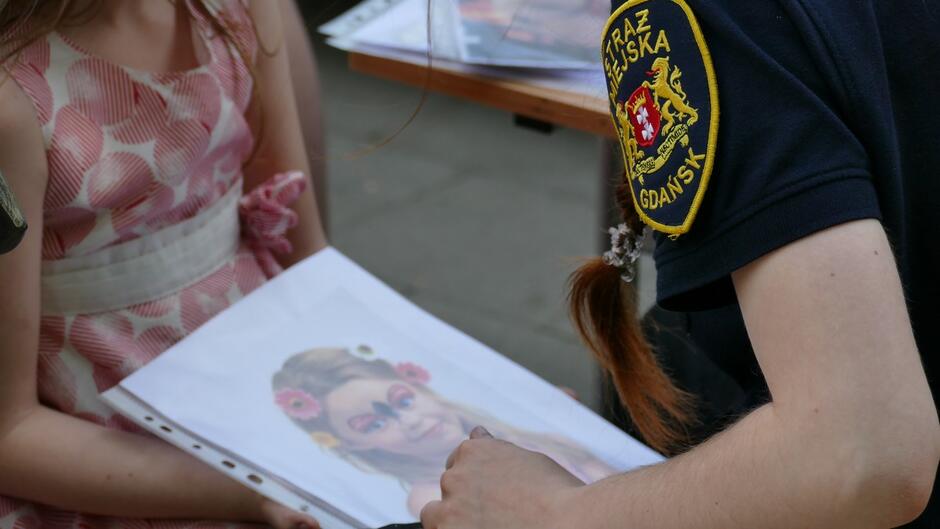 strażniczka trzyma obrazek z dzieckiem.JPG