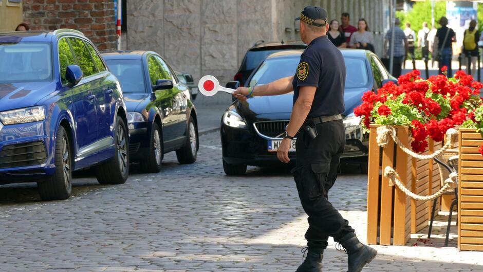 strażnik miejski z lizakiem zatrzymuje auto do kontroli