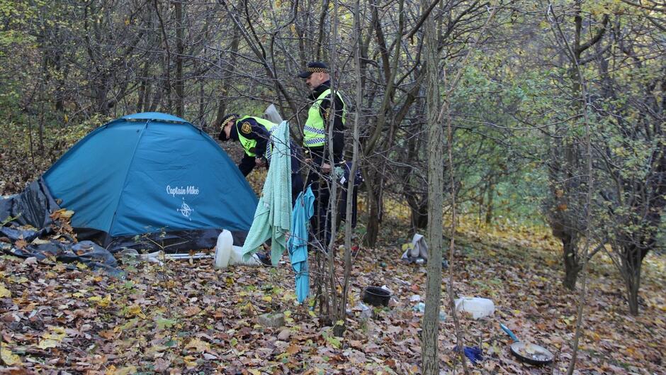 Strażnicy miejscy sprawdzają namiot stojący w środku lasu.JPG