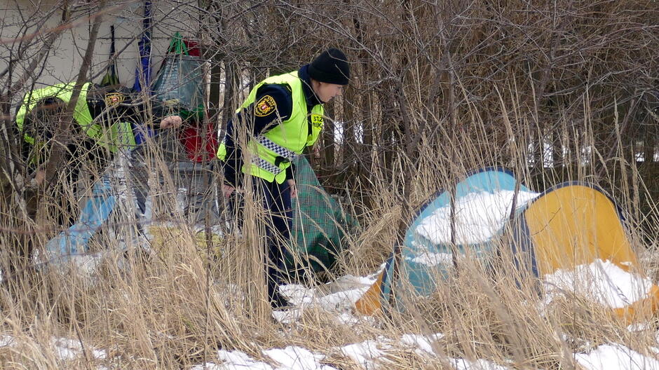 Strażnicy miejscy sprawdzają namioty w poszukiwaniu osób w kryzysie bezdomności. 