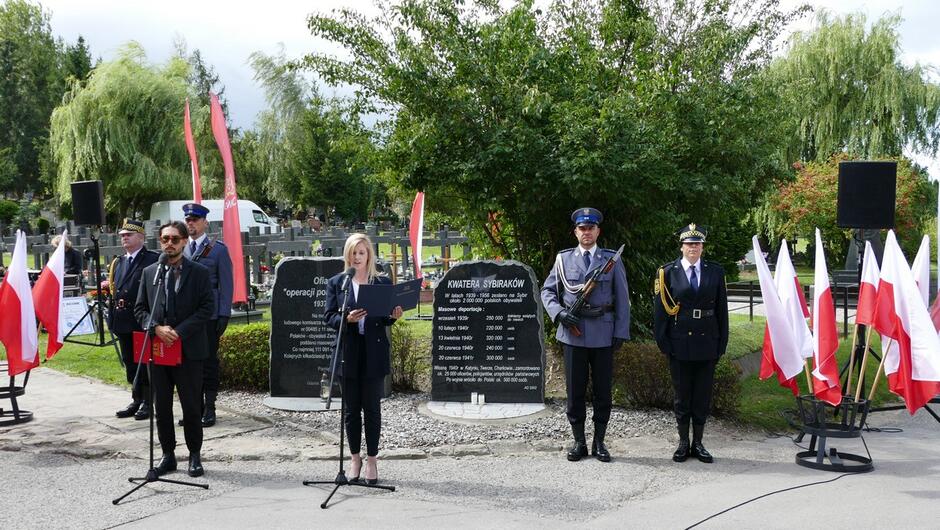 Na tle pomników i warty honorowej milicji i straży miejskiej przemawia zastępczyni prezydenta Gdańska Emilia Lodzińska. 