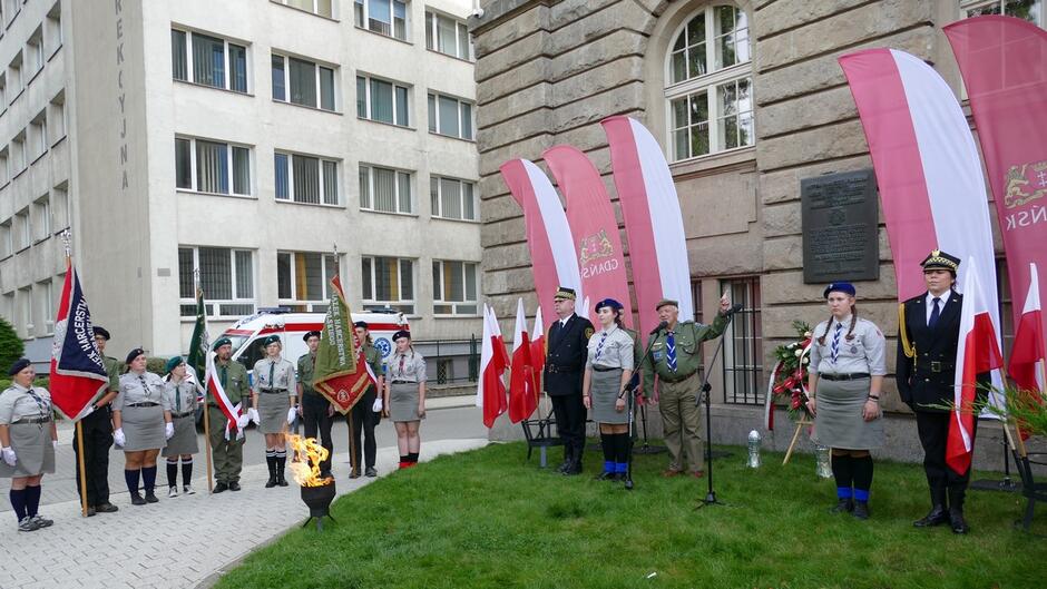 Warty honorowe oraz przemawiający harcerz przed płytą pamięci harcmistrza Jana Ożdżyńskiego.