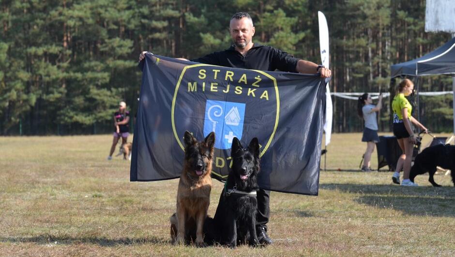 strażnik z flagą straży miejskiej i psami