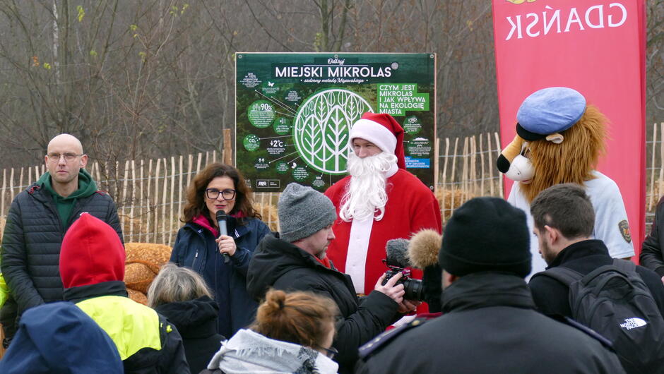 prezydent Gdańska przemawia do uczestników, po jej prawej dyrektor kryszewski, po lewej św. Mikołaj i strażowa maskotka lew Leoś