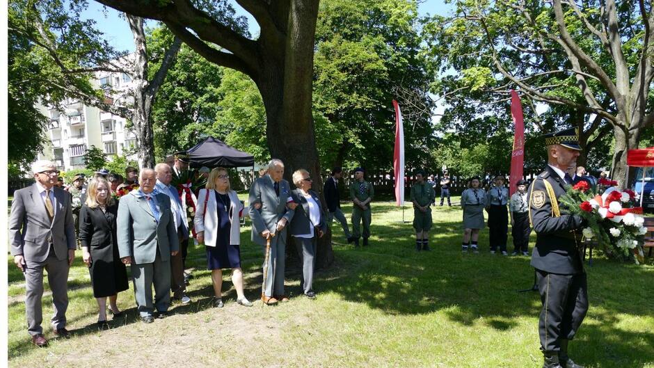 Strażnik miejski niesie wieniec, za nim delegacja województwa pomorskiego.