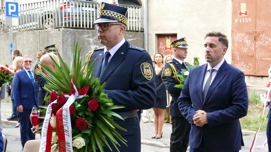 strażnik z wieńcem za nim iczestnicy