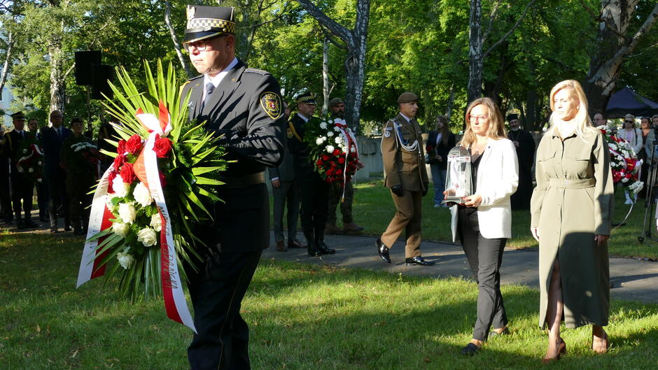strażnik z wiencem za nim uczestnicy