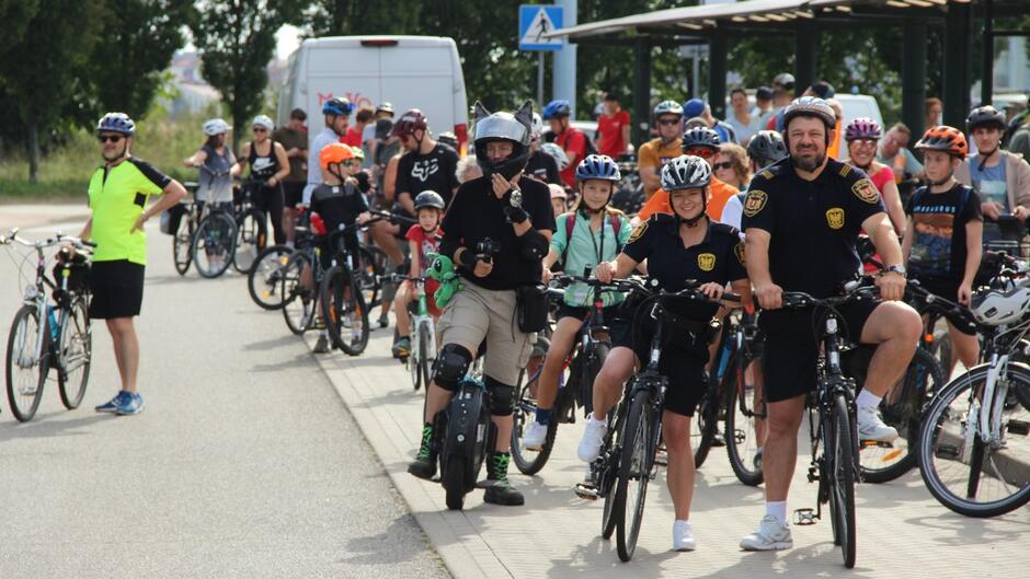 rowerzyści zebrani na pętli tramwajowej na przedzie z rowerami stoją strażnicy miejscy