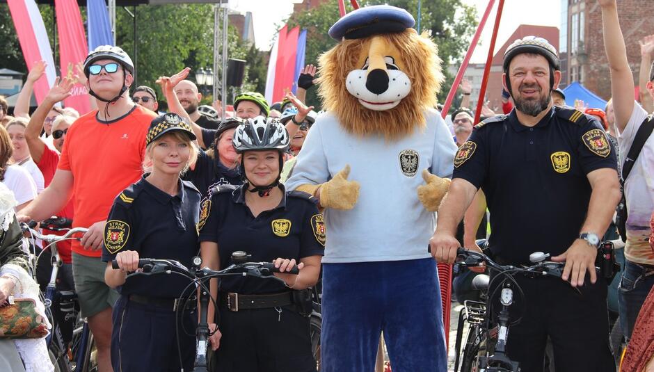 leoś strażnicy i rowerzyści pozują do wspólnego zdjęcia.
