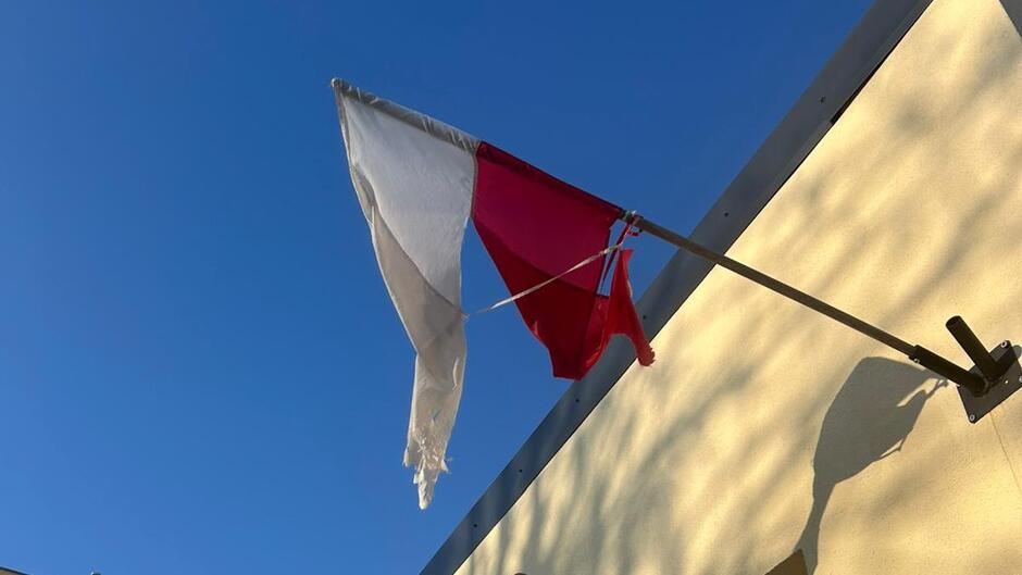 zniszczona polska flaga umieszczona w uchwycie 