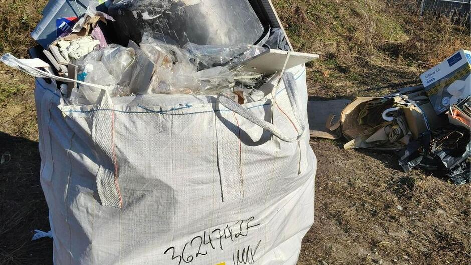 Przepełniony worek typu Big-Bag na trawniku.