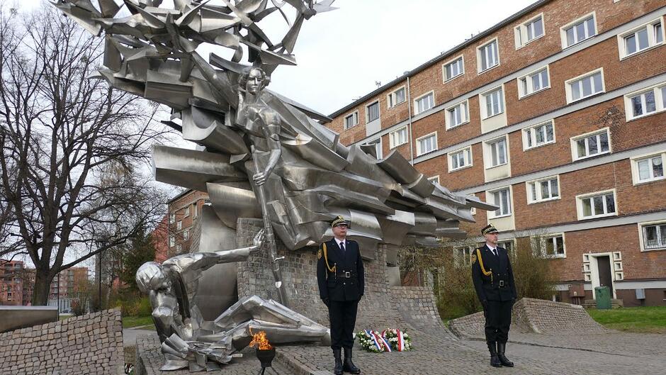Strażnicy miejscy pełnią wartę honorową przed Pomnikiem Obrońców Poczty Polskiej.