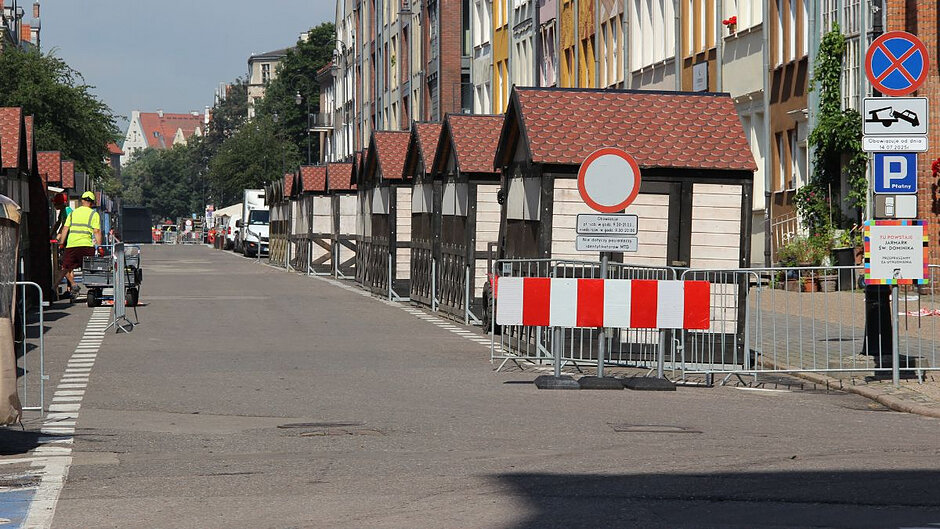 Ulica Szeroka w Gdańsku podczas przygotowań do Jarmarku św. Dominika - po obu stronach zamknięte budki handlowe. 