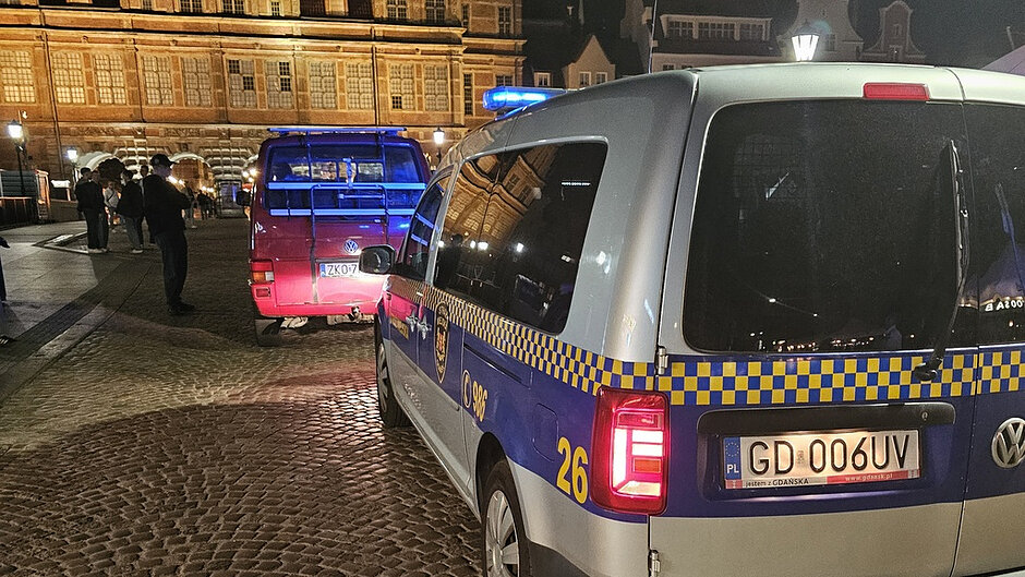 Pojazd Straży Miejskiej podczas czynności służbowych związanych z kontrolą pojazdu na terenie Rynku Starego Miasta w godzinach nocnych.