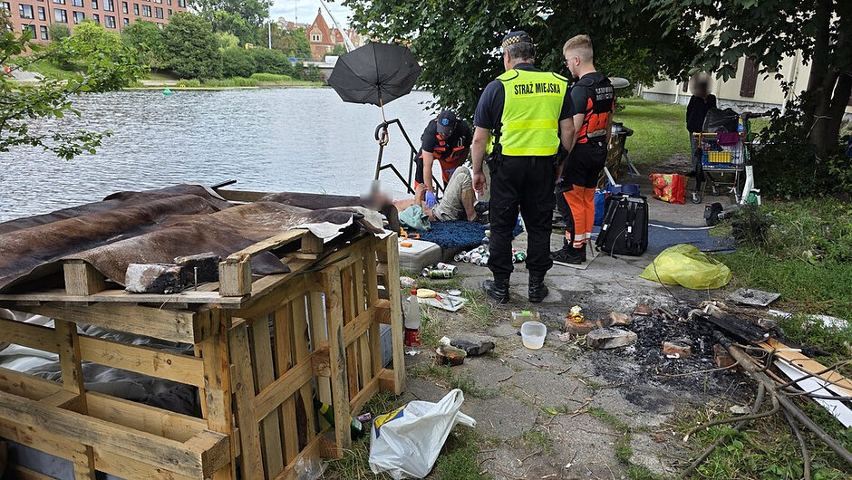 W rejonie nabrzeża ujawniono miejsce prowizorycznego bytowania osoby, składające się z konstrukcji wykonanej z drewnianych palet przykrytych zużytymi materiałami. Na miejscu znajdowały się liczne rzeczy osobiste, odpady komunalne, puszki, pojemniki oraz ślady po rozpalanym ognisku. W trakcie interwencji służby ratunkowe udzielały pomocy osobie przebywającej na terenie obozowiska, a czynności prowadzono przy udziale funkcjonariusza Straży Miejskiej. Miejsce zlokalizowane było bezpośrednio przy brzegu zbiornika wodnego, w pobliżu zabudowy miejskiej i terenów zielonych.