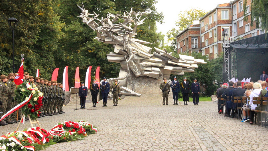 Uroczystość patriotyczna przy Pomniku Poległych Pocztowców Polskich w Gdańsku. W obchodach uczestniczą przedstawiciele służb mundurowych, Wojska Polskiego oraz mieszkańcy miasta. Przed pomnikiem złożono wieńce i wiązanki kwiatów w barwach narodowych, oddając hołd obrońcom Poczty Polskiej w Gdańsku poległym we wrześniu 1939 roku. Ceremonię uświetniają poczty sztandarowe oraz asysta honorowa, podkreślając podniosły i patriotyczny charakter wydarzenia.