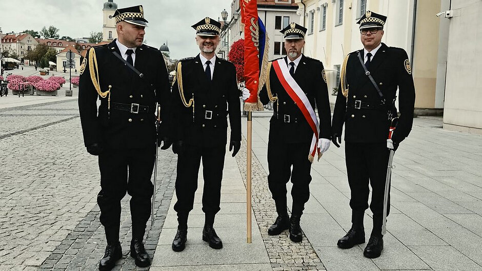 Funkcjonariusze straży miejskiej wraz z pocztem sztandarowym podczas oficjalnych obchodów patriotycznych.