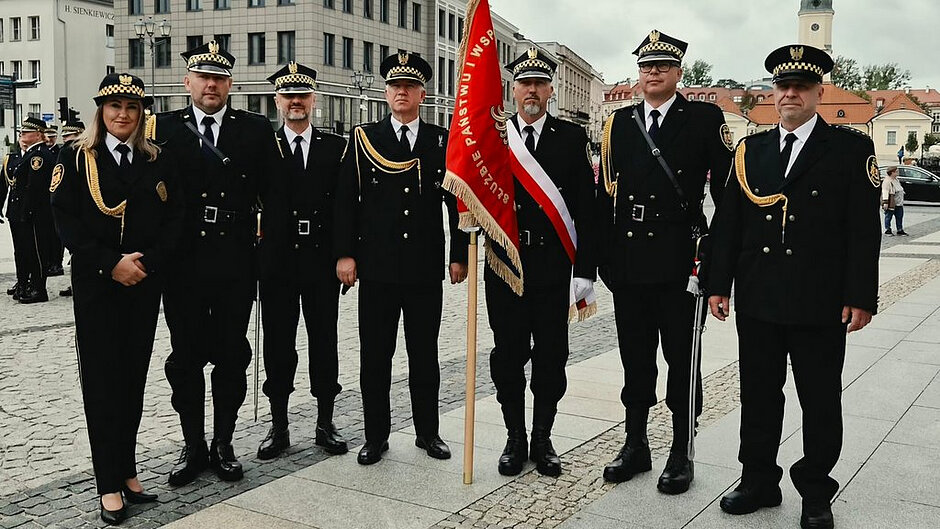 Funkcjonariusze straży miejskiej wraz z pocztem sztandarowym podczas oficjalnych obchodów patriotycznych.