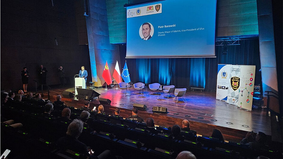Na scenie za mównicą stoi Piotr Borawski, który otwiera konferencję sieci EU-POLNET.