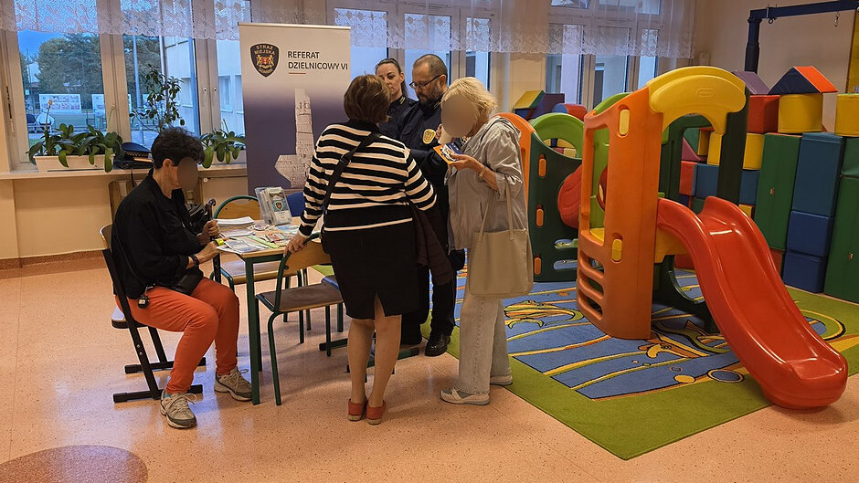 Przy stoisku informacyjnym Straży Miejskiej mieszkańcy rozmawiają z funkcjonariuszami o kwestiach związanych z bezpieczeństwem i porządkiem publicznym. Na miejscu dostępne są materiały informacyjne oraz możliwość uzyskania porad.