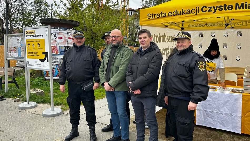 strażnicy z urzędnikami stoją przed namiotem Czyste Miasto Gdańsk