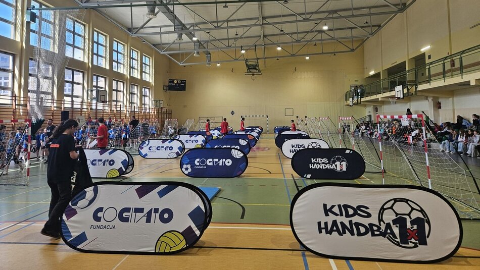 hala sportowa zawodnicy biegają na boisku rozstawione banery